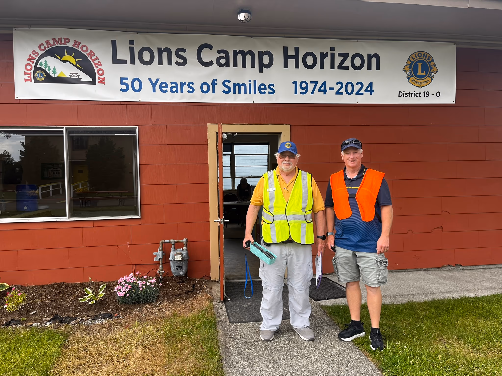 Men ready for construction in front of a Lions Camp Horizon building